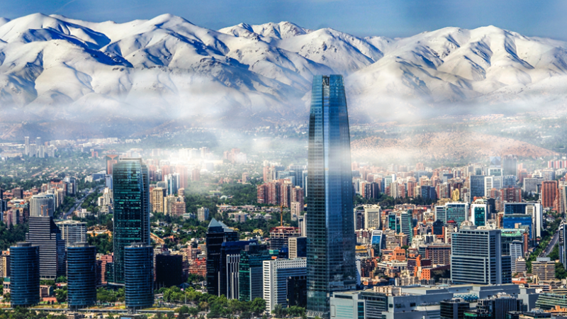 Vista aérea de Las Condes, Santiago, con la Torre Costanera y la cordillera de los Andes nevada al fondo.