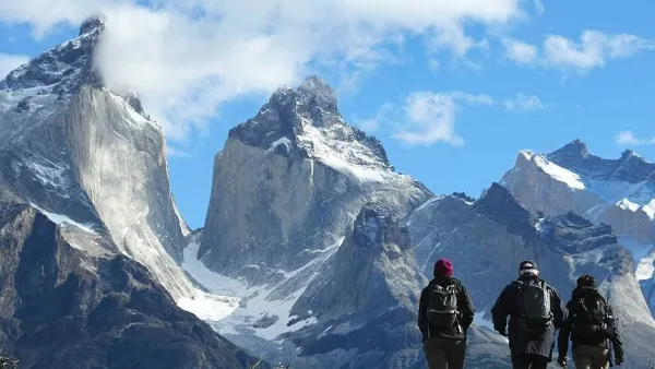 Las escarpadas y oscuras formaciones rocosas de los Cuernos del Paine bajo un cielo azul intenso.